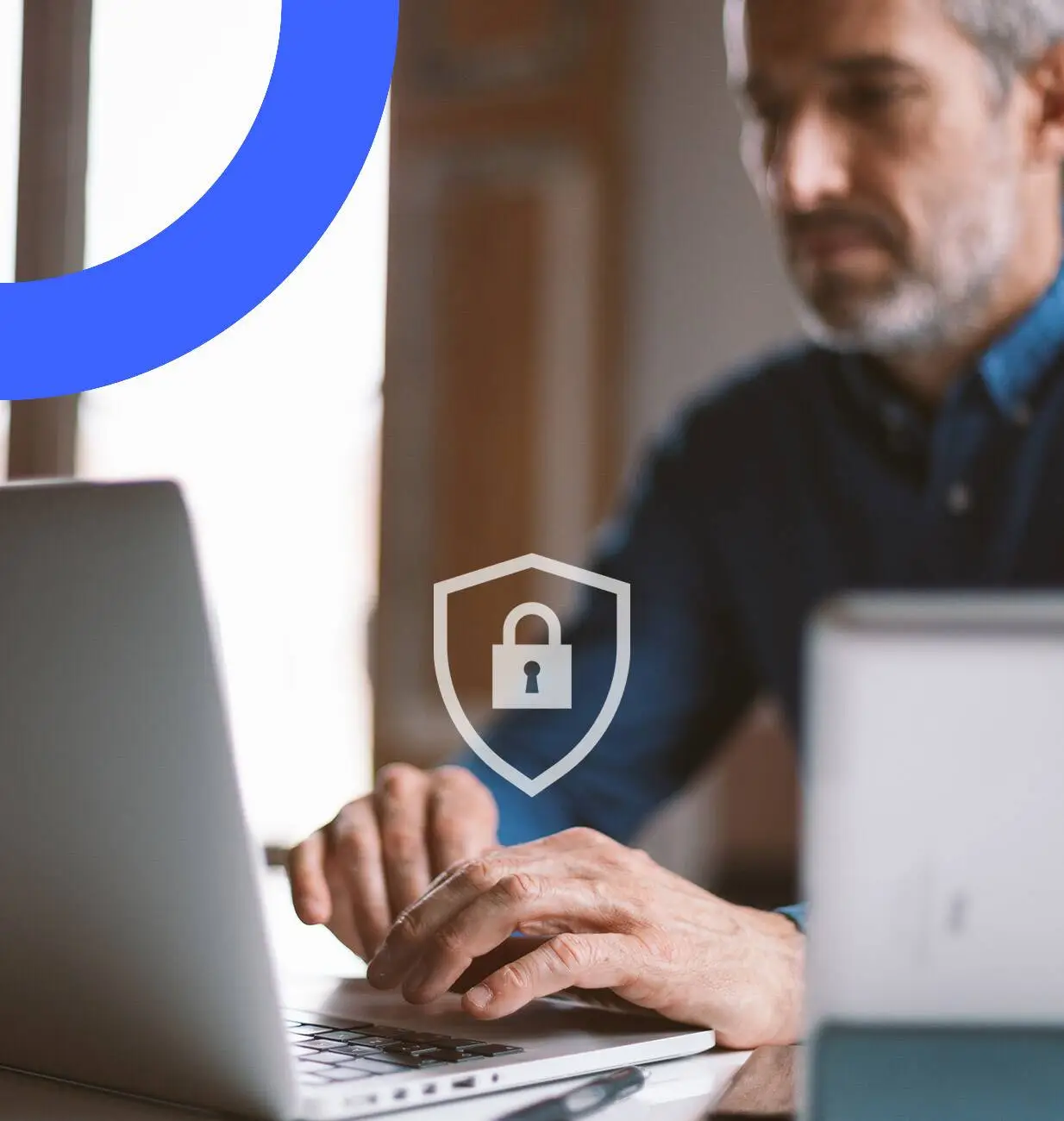 Man typing on a laptop, with a badge with a secure lock overlaid on the image.