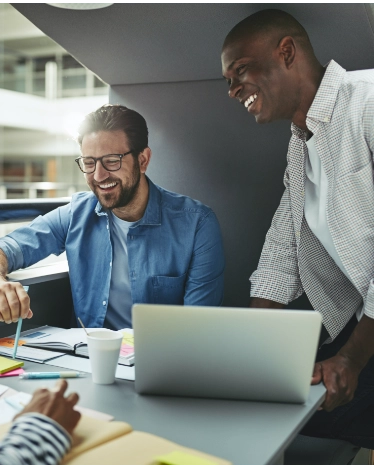 Two proposal managers are happily smiling while working on a Request for Proposal