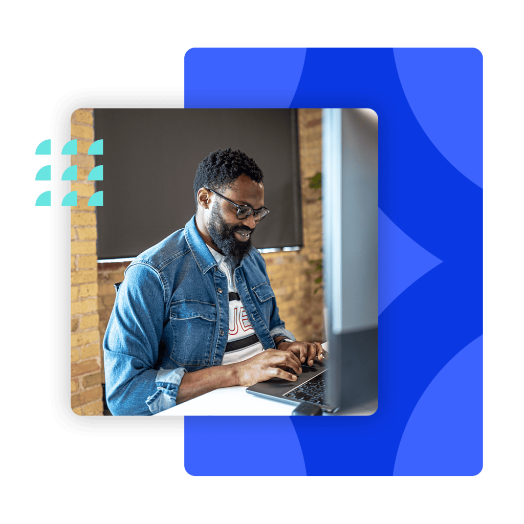 A Loopio employee is typing on a keyboard and smiling.