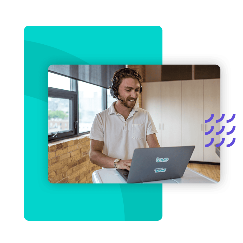 A Loopio employee with a headset and a laptop is attending a virtual meeting.